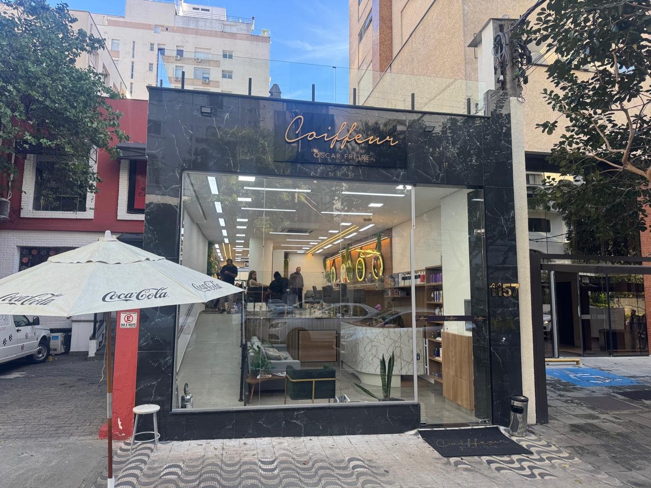 Fachada de mármore preto do Coiffeur Oscar Freire com o letreiro dourado, na Rua José Maria Lisboa