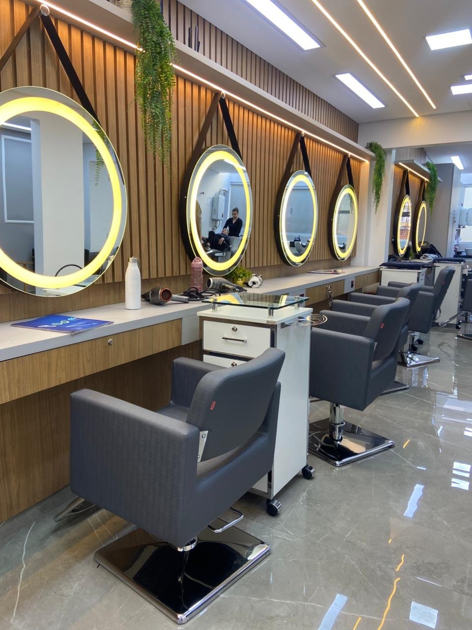 Estação de atendimento com espelho redondo e acabamento em mármore no Coiffeur Oscar Freire